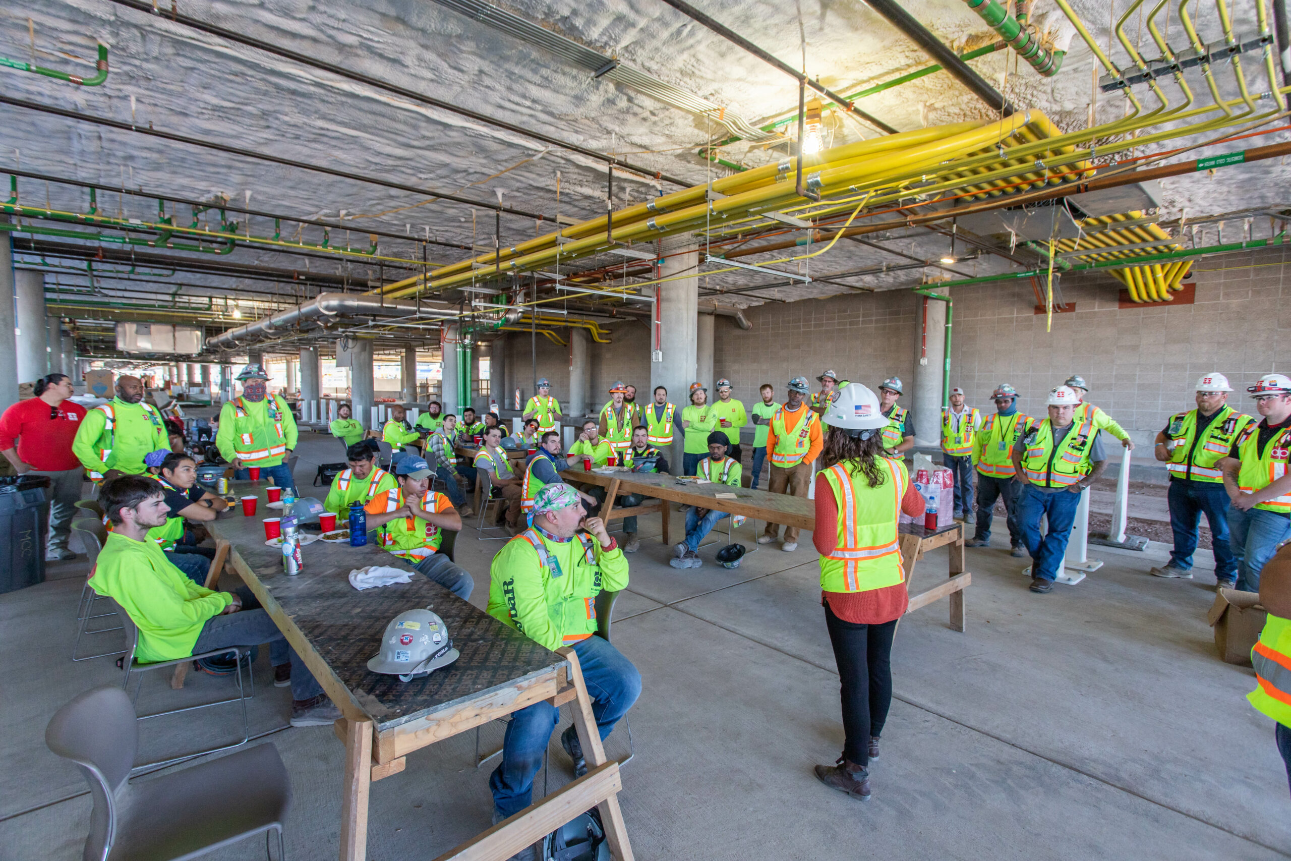 A group of construction workers, including Danielle, standing in a room.