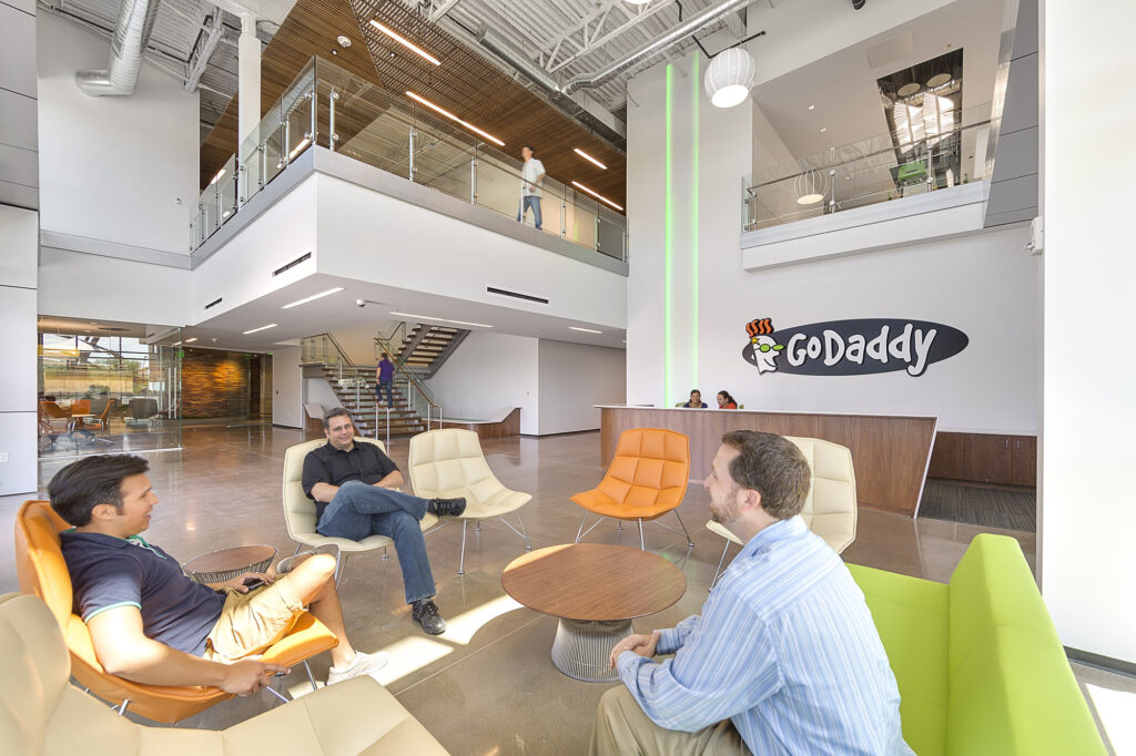 A group of people sitting in chairs in a GoDaddy office.