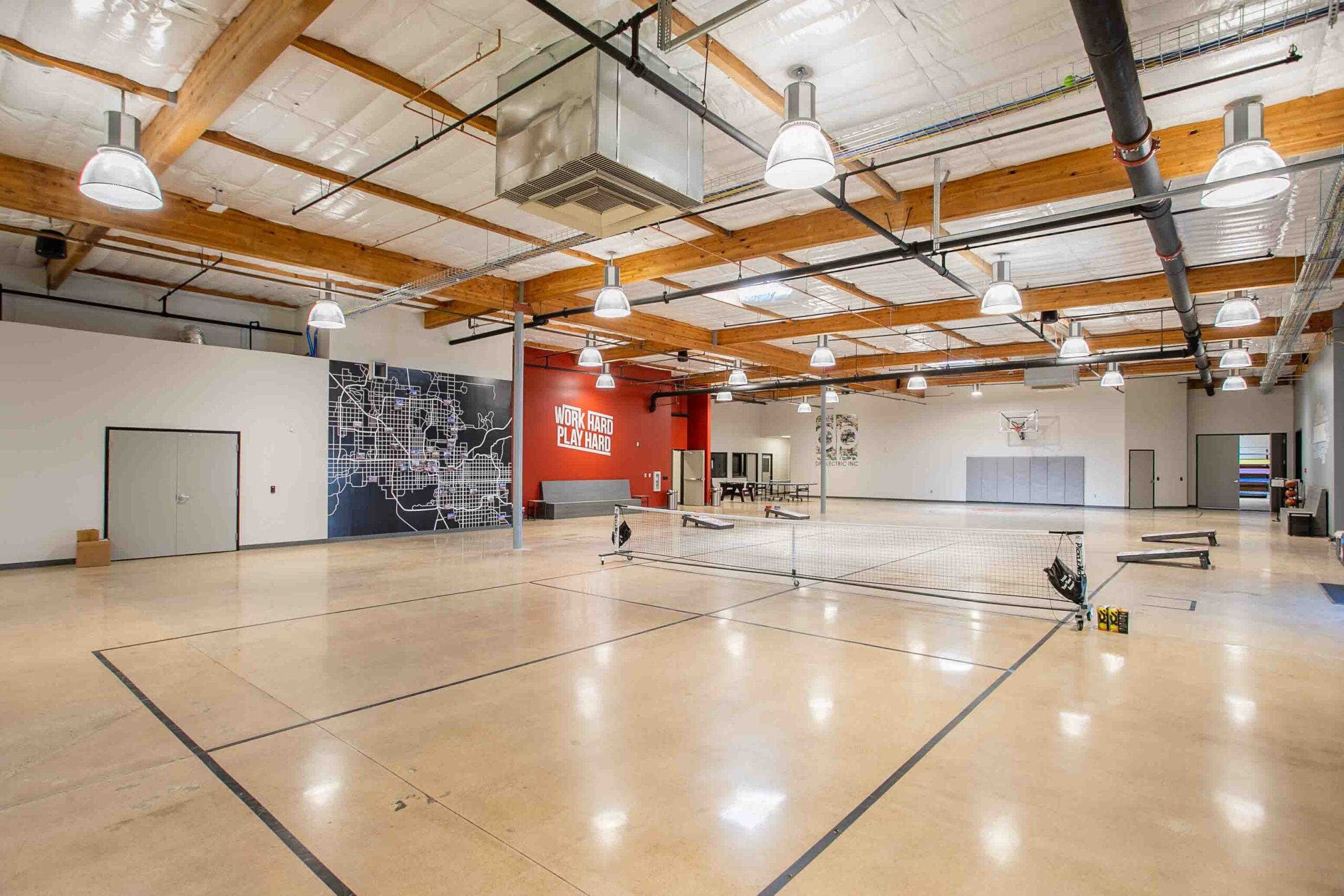 A large gym with a basketball court and a basketball hoop.