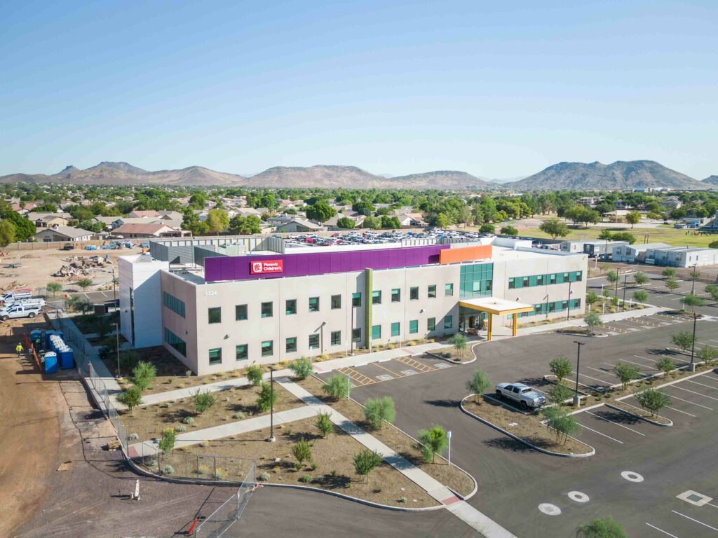 An aerial view of a purple building with mountains in the background.
