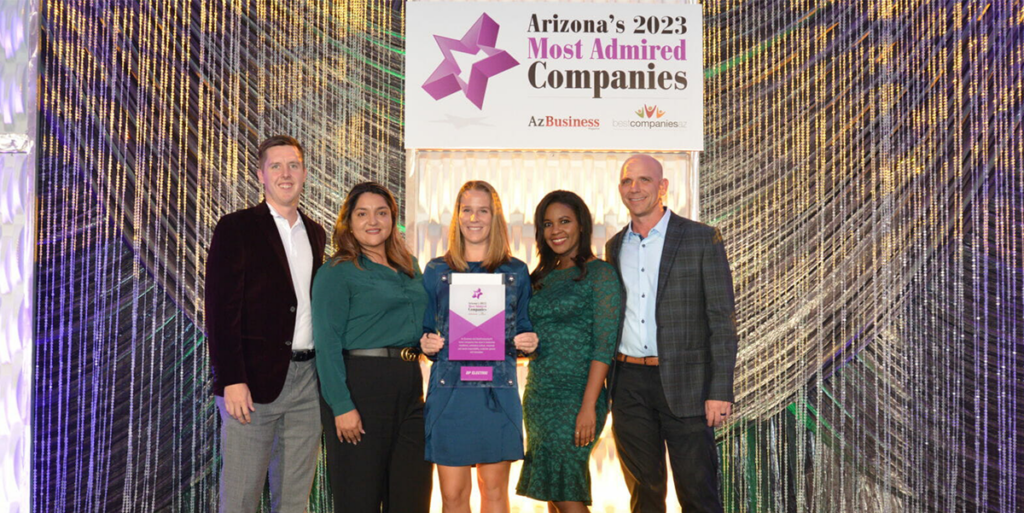 A group of people posing for a picture with an award as DP Electric Announced Most Admired Company for 2023.